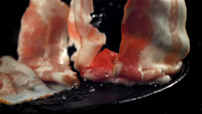 Raw bacon falls into the plate. Filmed on a high-speed camera at 1000 fps. High quality FullHD footage