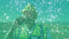 Wind energy technician talking on smartphone in wind farm field, showing digital network overlay. Renewable, technology, professional, eco-friendly, sustainable, modern, outdoor - Powered by Shutterstock - Get 15% off with code: PIKWIZARD15