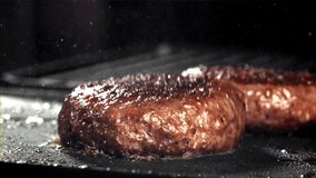 A beef burger falls into a hot pan with a splash of oil. Filmed on a high-speed camera at 1000 fps. High quality FullHD footage - Powered by Shutterstock - Get 15% off with code: PIKWIZARD15