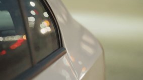 Close up side view of parked car under night streetlight, showing blurred reflections of cars moving behind, captured through smooth glass window with bokeh glow and subtle vehicle outlines - Powered by Shutterstock - Get 15% off with code: PIKWIZARD15