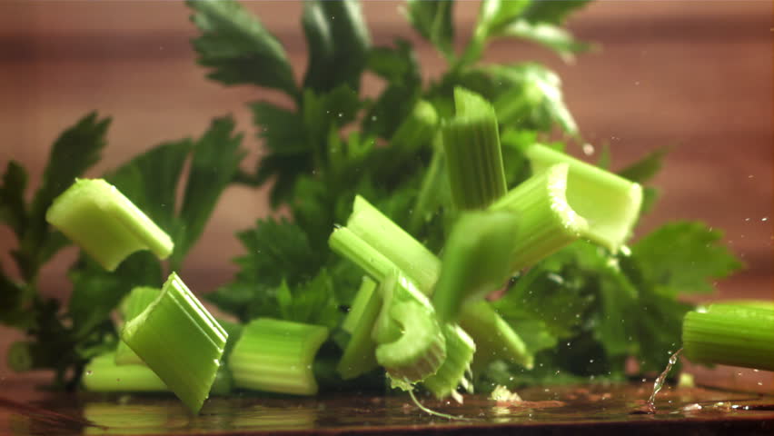 Pieces of chopped celery fall on the table. Filmed on a high-speed camera at 1000 fps. High quality FullHD footage