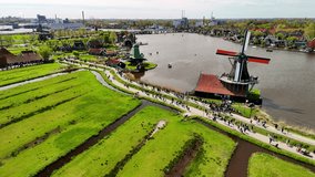  Aerial drone view of beautiful wooden windmills in the Dutch village of Zaanse Schans. The windmills run on wind. The Dutch canals are filled with water. Located near the city of Zaandam. - Powered by Shutterstock - Get 15% off with code: PIKWIZARD15
