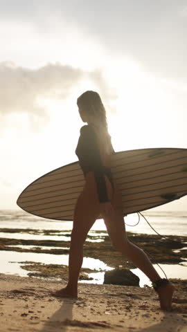 Young Woman with Surfboard Walking Coastline at Vibrant Sunset