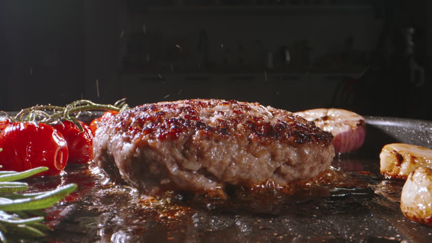 Chef takes frying pork cutlet and turns around using kitchen spatulas on pan preparing Burger. Cinematic advertising burger cooking. Crispy, golden brown cutlets with slice of cheese, keto low-carb