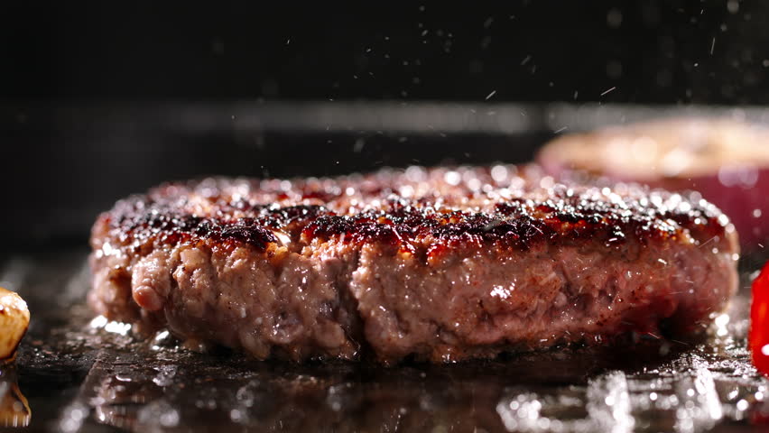 Sprig of rosemary is placed on pork cutlet fried on both sides during frying process. Cinematic advertising burger cooking. Crispy texture and savory flavor of fried cutlets. Fat high calorie food