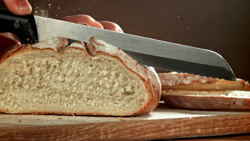 The chef slices fresh bread. Filmed on a high-speed camera at 1000 fps. High quality FullHD footage