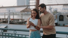 Portrait of young Latin American man and woman take selfie on smartphone near tourist ship. Happy Hispanic tourists pose for picture in resort city port. Romantic vacation together - Powered by Shutterstock - Get 15% off with code: PIKWIZARD15