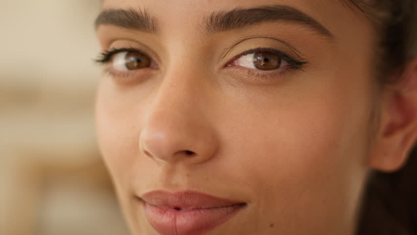 Extreme close up face Indian beautiful healthy woman Arabian satisfied carefree smiling businesswoman business girl medicine health beauty treatment skin care natural make-up looking at camera at home