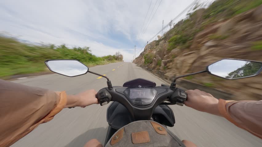 Riding a scooter along a scenic coastal road with stunning views