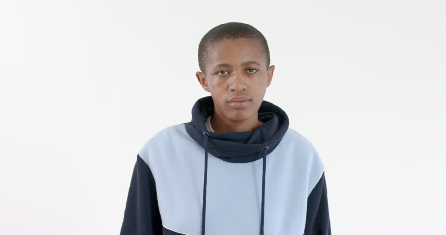 High speed photography for dynamic scenes, Person wearing hoodie standing and looking at camera with neutral expression. Fashion, casual, urban, streetwear, portrait, style