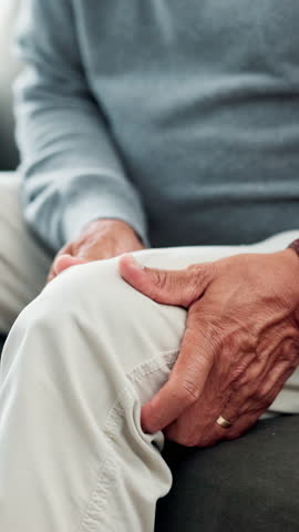 Home, hands and senior man with knee pain, inflammation and osteoporosis in lounge. Pensioner, closeup or mature person with bruise, muscle tension or strain with ache, medical emergency or arthritis
