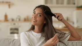 Happy smiling relaxing woman Arabian female Indian girl self care beauty routine attractive combing dark healthy hair with comb hairbrush brushing hairstyle haircare shampoo mask conditioner at home - Powered by Shutterstock - Get 15% off with code: PIKWIZARD15