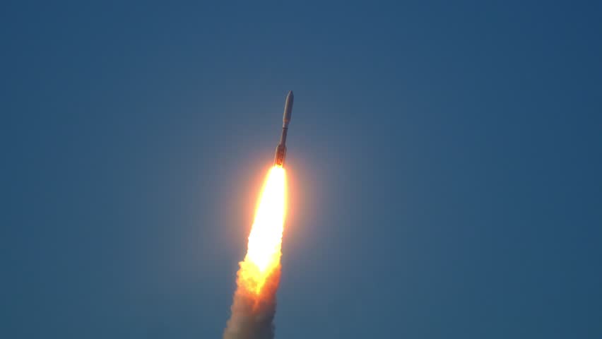 Space Rocket flies into the evening sky as it carries communications satellites into earth orbit in space. Lots of flames and smoke. With Audio.