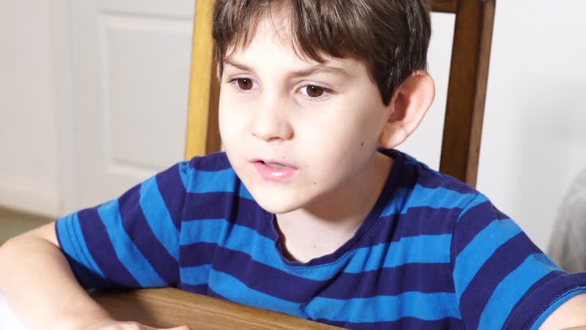 Boy is studing at home, doing homework