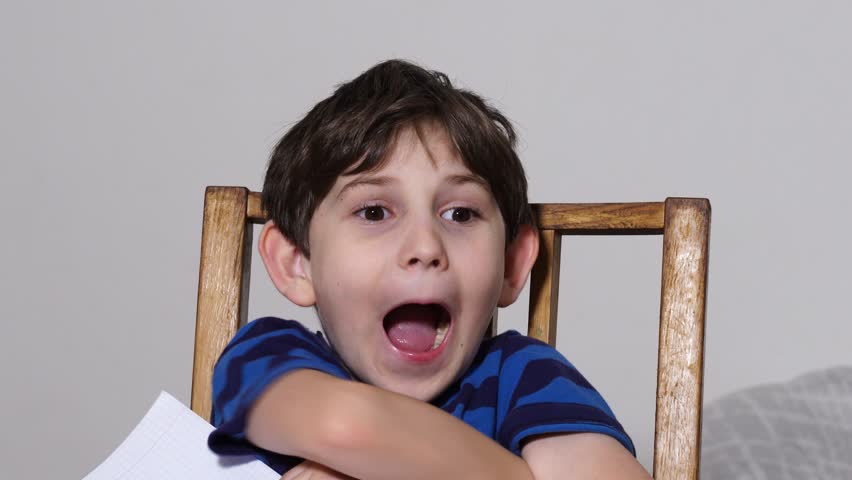 Boy is studing at home, doing homework