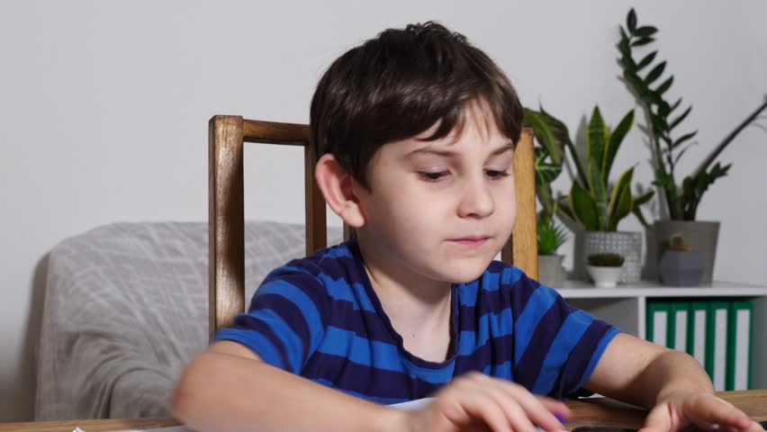 Boy is studing at home, doing homework