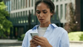 Smiling positive ethnic business woman African American businesswoman girl lady female in city looking mobile phone reading bad news problem smartphone change mood emotion negative upset failure lost - Powered by Shutterstock - Get 15% off with code: PIKWIZARD15