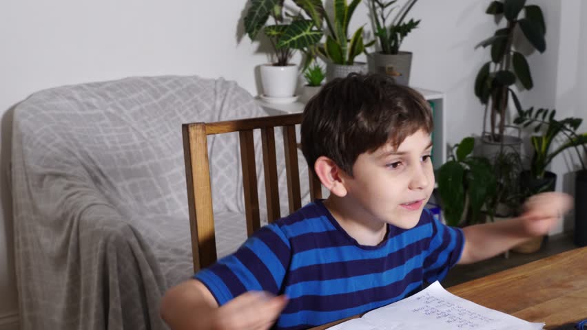 Boy is studing at home, doing homework