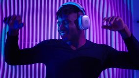 African American man guy male dancing DJ mix listening audio song sound music in modern wireless headphones dance having fun at house party with neon light modern movements relaxing freedom moving - Powered by Shutterstock - Get 15% off with code: PIKWIZARD15