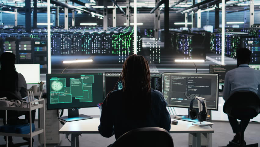 Server hub admin responds to cyberattack attempting to access confidential data while securing hardware systems. Data center worker fighting malware intrusion during security incident, camera A
