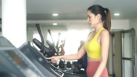 Healthy Asian woman checks heart rate and calories burned on smart watch screen at fitness gym. Sporty girl do sport training workout cardio exercise running on treadmill. Healthcare motivation. - Powered by Shutterstock - Get 15% off with code: PIKWIZARD15