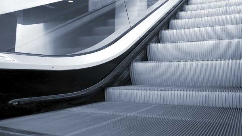 Up and down escalators in public building, nobody. Blue tone