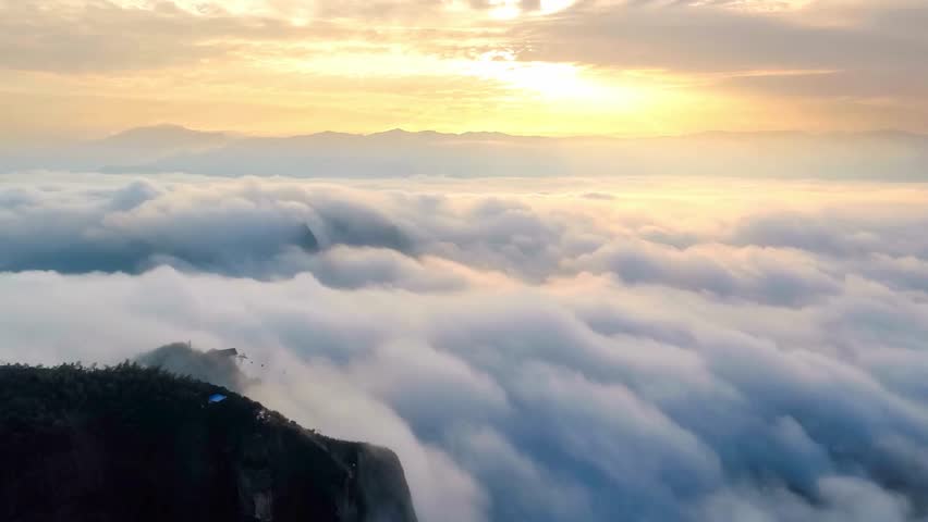 Aerial View of Mountain Peak Above Cloud Sea at Sunset