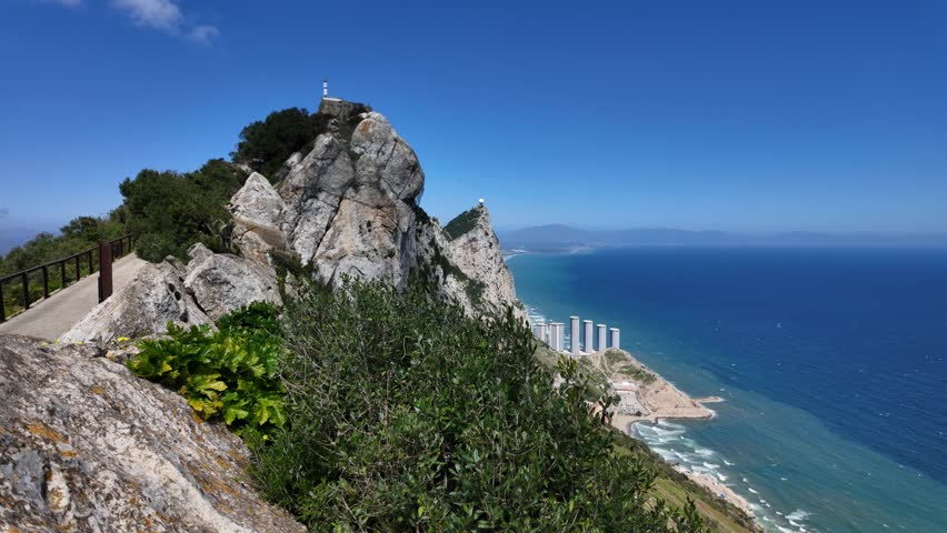 Scenic view of Gibraltar rock from a hiking trail, showcasing mediterranean sea and clear blue sky