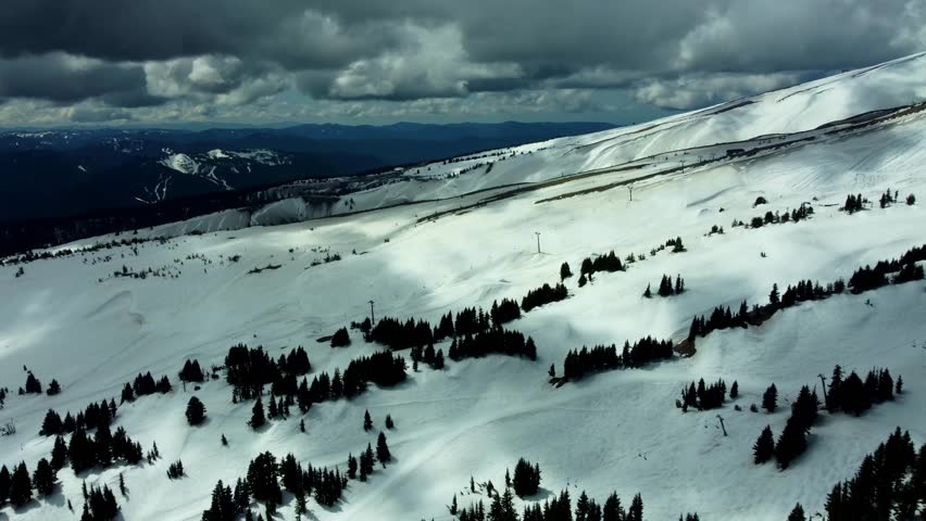 US, Oregon, Mt Hood, Meadows Ski Area, 2025-04-22 - Drone view of Mt Hood at the Mt Hood Meadows ski area in spring. Flying across the ski runs and lifts towards Timberline.