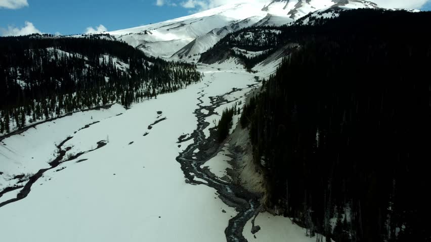 US, Oregon, Mt Hood, White River, 2025-04-22 - Drone view of the frozen river that comes down from Mt Hood. On a beautiful spring day.