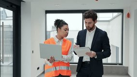 Professional architect and construction engineer discuss building plans in a modern office. They feel focused and determined. - Powered by Shutterstock - Get 15% off with code: PIKWIZARD15