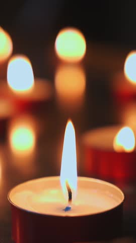 Many candles burn in the dark. Memorial day with candles. Lighted memorial candles. Funeral candles close-up. High quality 4k footage