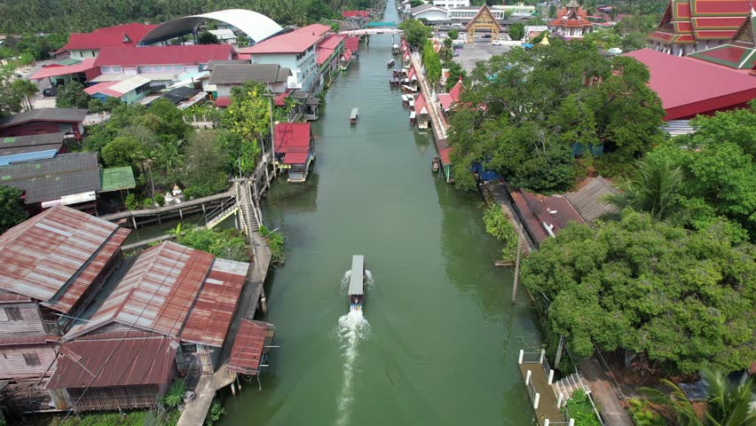 Aerial view of a longtail boat sailing in canal. Floating market in Ratchaburi, Thailand 