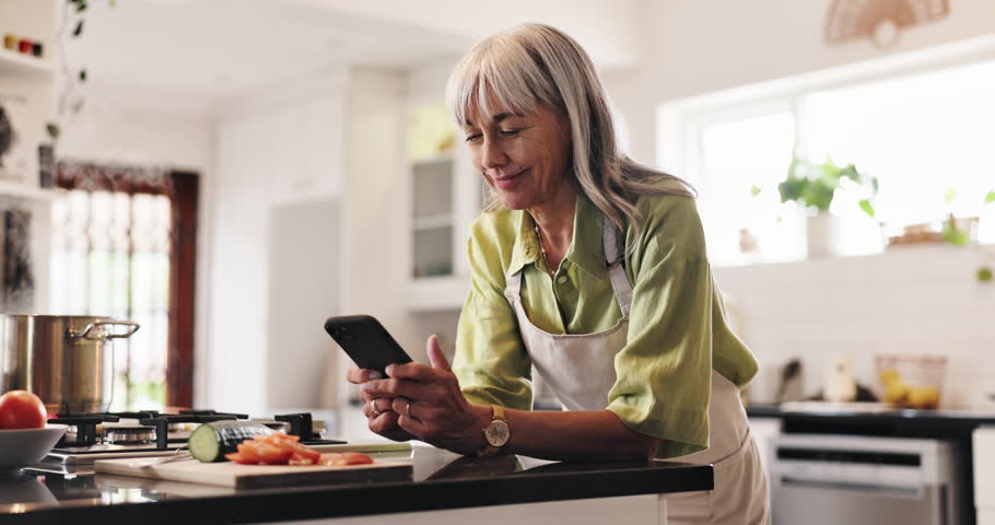 Cooking, phone and reading with old woman in kitchen for food blog recipe, nutrition tracking and health app. Meal prep, dinner planning and retirement with senior person at home for vegetables