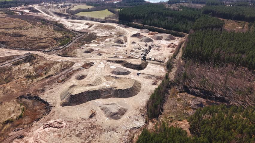Large-scale dolomite mining operation viewed from above, showing machinery and terrain