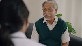Elderly Asian man smiling while talking to female doctor during medical consultation at clinic. Trusting conversation in healthcare environment. - Powered by Shutterstock - Get 15% off with code: PIKWIZARD15