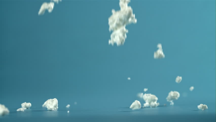Fresh cottage cheese falling on blue background. Filmed on a high-speed camera at 1000 fps. High quality FullHD footage