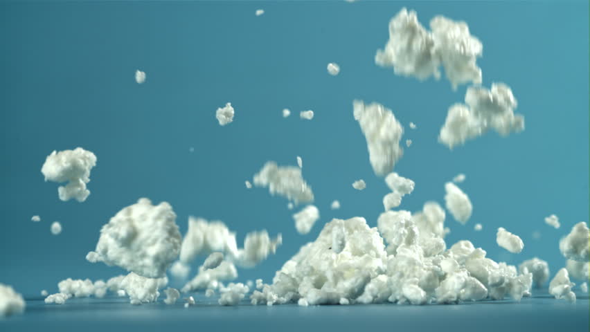 Fresh cottage cheese falling on blue background. Filmed on a high-speed camera at 1000 fps. High quality FullHD footage