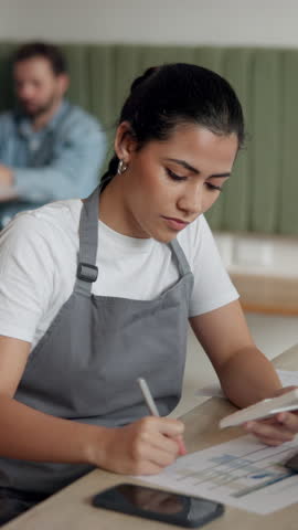 Cafe, entrepreneur and woman with documents, reading or calculations for financial planning or budget. Hospitality, server and person with paperwork for inventory, calculator or review in coffee shop