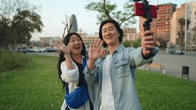 Asian couple friends recording selfie video travel vlog with mobile phone for social media talking to camera - Powered by Shutterstock - Get 15% off with code: PIKWIZARD15
