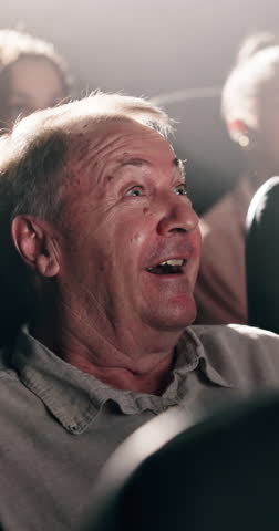 Senior, happy man and surprise with movie at cinema for suspense, shock or entertainment. Elderly, male person or watching with smile, wow or fright for performance or motion picture in dark theater
