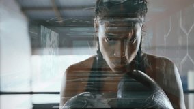 Female boxer training in gym with boxing gloves, displaying holographic health analytics. Athlete, fitness, futuristic, technology, empowerment, strength, determination - Powered by Shutterstock - Get 15% off with code: PIKWIZARD15