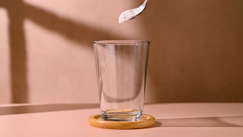 Collagen powder pouring in a glass. Food supplement, fitness sport, health and nutrition.