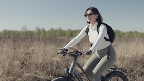 Woman on holiday rides her bicycle through a sunlit national park at midday, blending outdoor leisure with eco-friendly travel through wide open natural spaces - Powered by Shutterstock - Get 15% off with code: PIKWIZARD15