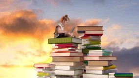 A young girl sitting on a stack of books, focused on using a laptop. The image symbolizes learning and childhood education. - Powered by Shutterstock - Get 15% off with code: PIKWIZARD15