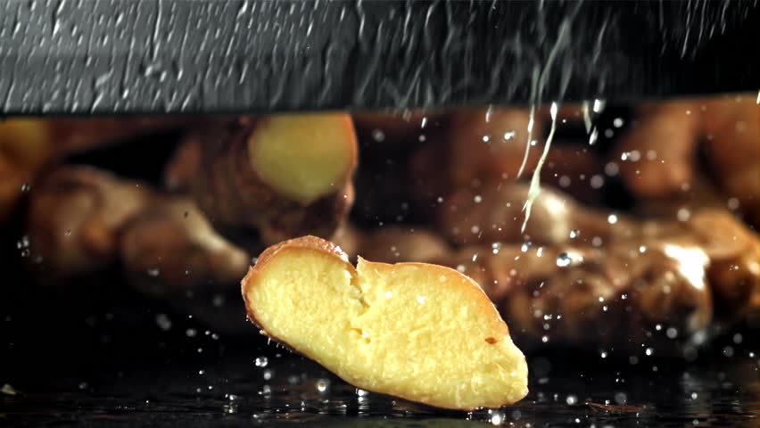 A knife cuts through fresh ginger. Filmed on a high-speed camera at 1000 fps. High quality FullHD footage