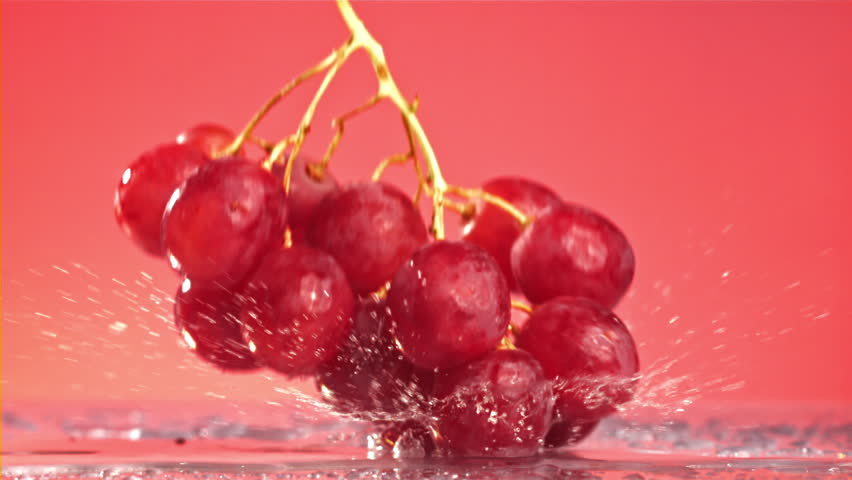 Red grapes fall with splashes on a wet table. Filmed on a high-speed camera at 1000 fps. High quality FullHD footage