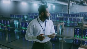 Big Data Center with Server Racks: Professional African American Specialist Using Tablet Computer, Activating Servers, Standing In Warehouse. Information Technology and Cyber Security. Medium Shot. - Powered by Shutterstock - Get 15% off with code: PIKWIZARD15