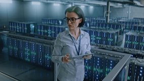 Big Data Center with Server Racks: Female Administrator Using Tablet Computer, Activating Servers Standing In Warehouse. Concept of Information Technology, Machine Learning, Web Service. Medium Shot. - Powered by Shutterstock - Get 15% off with code: PIKWIZARD15