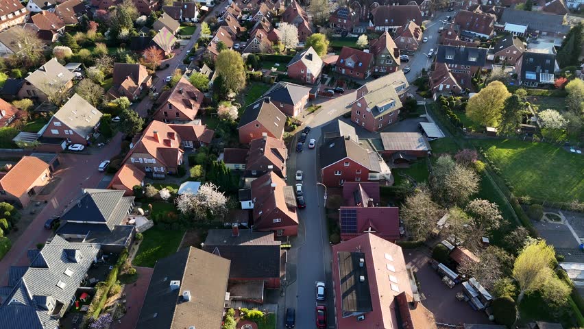Cars on street of historic american town during sunset time. Aerial top down flyover shot. Tracking shot. Red orange tiles on roof with colored trees in springtime.